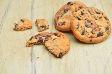 Golden brown, chocolate chip cookies over wooden table.