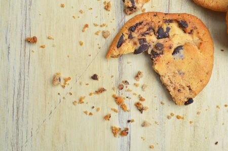 Golden brown, chocolate chip cookies over wooden table.の写真素材
