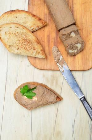 Roll pate, slices of toasted bread, wooden background. Top view.の写真素材