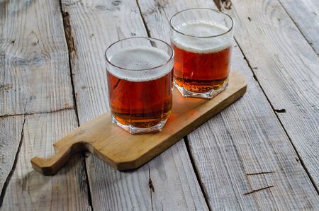 Fresh beer with foam on wooden tableの写真素材