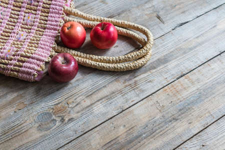 Fresh apples in a bag on a wooden backgroundの写真素材