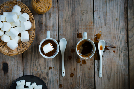 Two cups of hot coffee with marshmallows and cookies on wooden background, top view, close up.の写真素材