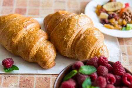 A healthy breakfast, croissants, raspberry and candied fruits.の写真素材
