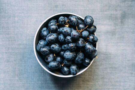 Dark grapes in plate, fresh grapes in the plate, top view.の写真素材