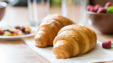 Croissants, raspberries and candied fruits on the table, healthy breakfast.の写真素材