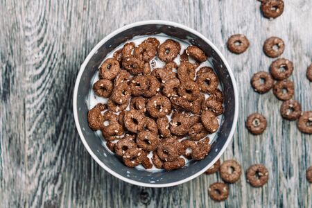 Chocolate balls with milk in a gray plate on a wooden background. Slightly balls are scattered on the table. View from above.の写真素材