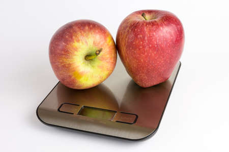 Apple over weight scale with white backgroundの写真素材