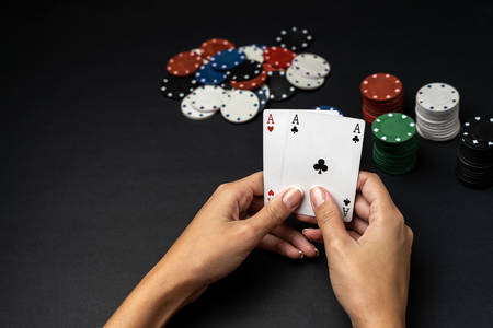 Stack of chips and woman hand with two aces on the table. Poker game conceptの写真素材