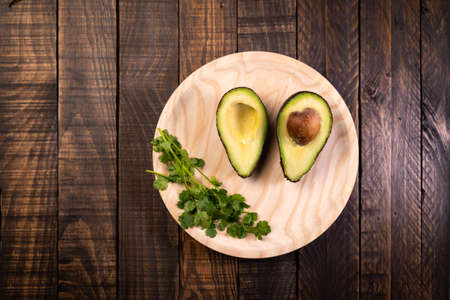 Avocado split in half on wood. Healthy and vegetarian food