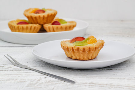 Small fruit pia cake on a textured white background. Kue Pia Buah.