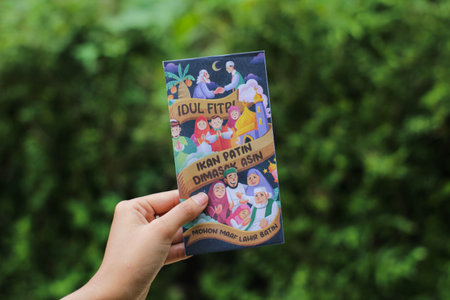 Banjarnegara, May 2023: A woman holds a THR envelope for gifts on Eid al-Fitr.