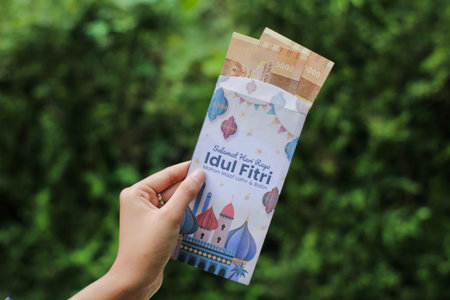 Banjarnegara, May 2023: A woman holds a THR envelope filled with money for gifts on Eid al-Fitr.