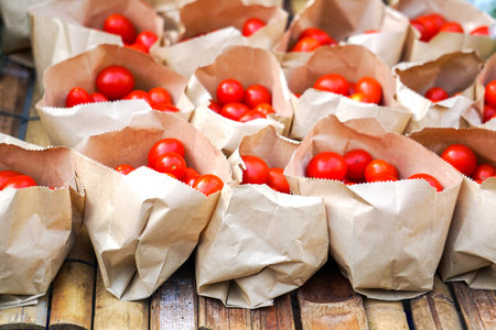 Fresh tomatoes, packaged in a brown paper bag and bought from a local farmer's market. - Imageの写真素材