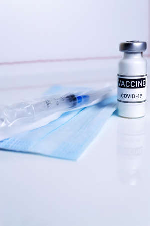 Vertical photography. Coronavirus vaccination medical concept. Vaccine dose on a white background...