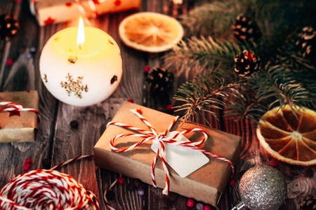 christmas home decorations gifts in craft paper on dark wooden background close-up.の写真素材