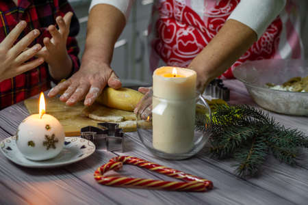 Preparing to bake christmas gingerbread cookies, woman's hands stirring the dough close-up.の写真素材