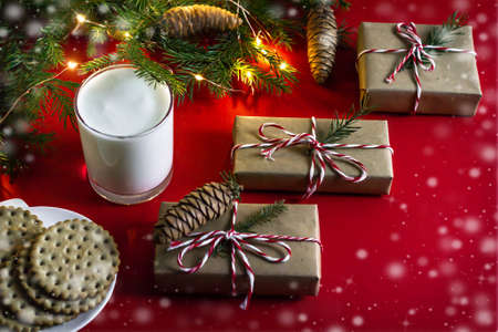Christmas treat for Santa Claus milk and cookies, gifts on a red background, top view.の写真素材