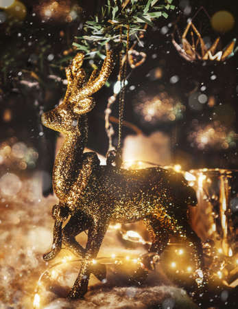 Vertical picture Christmas card. Golden deer on a dark snowy background.の写真素材