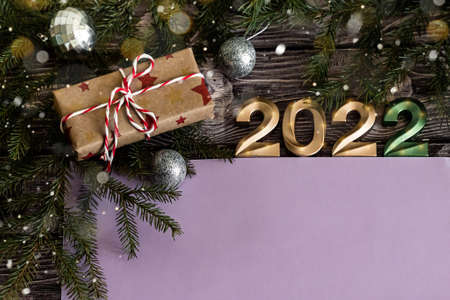 Christmas flat lay composition of craft gifts and golden numbers 2022 on dark wooden background with...