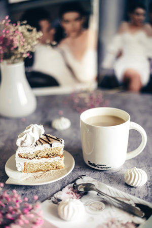 Vertical photo of a sweet breakfast piece of cake and a cup of cappuccino on a gray background, a beautiful good morning.の写真素材