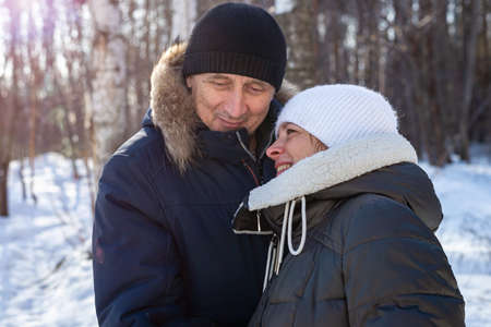Elderly couple hugging each other in the countryside in the winter forest, family relationship. Life style, close-up portrait.の写真素材