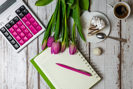 Flat lay view of the surface of the desktop holiday in the financial sphere tulips coffee with a...