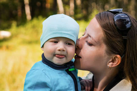 Loving mother hugs her sweet son, feels tenderness, mother hugs and holds the child in her arms, warm relationship, child custody.の写真素材