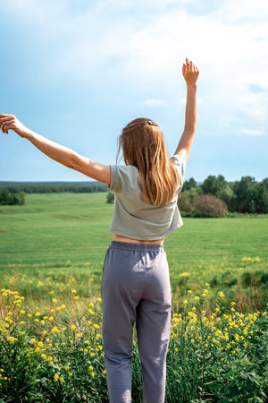 Beautiful girl outdoors enjoying nature near the forest, rear view lifestyle, the concept of unity...