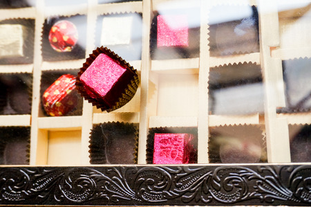 Ornate box of chocolates with an engraved box and ribbon tied to it