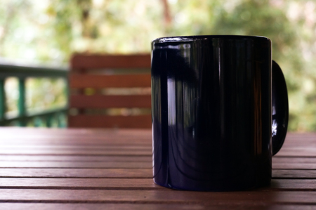Purple mug on a wooden table with a wooden.の写真素材