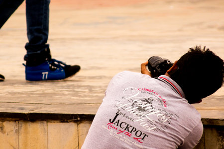 Photographer capturing a walking person wearing blue shoes. Shooting from a low angle.のeditorial素材