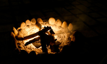 Campfire in a firepit with a stone border and wood sticks. A necessary part of evey camping trip