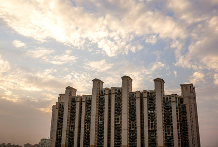 Multistoried apartments in Gurgaon India against a colorful cloudy sky.のeditorial素材