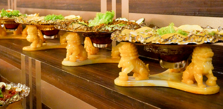 Plates of salad kept on lion shaped plate stands. This selection of salads is usually served in Indian weddingsの写真素材