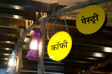 Hindi coffee and pasty signs near a lantern in a village restaurant or motel. Opening village themed coffee joints is a popular business ideaのeditorial素材