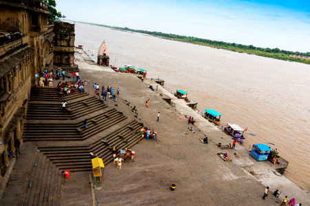 Maheshwar, India - 16th July 2016: People climbing down the huge flight of stairs at the bank of the Narmada river from the Maheshwar fort in Madhya Pradeshのeditorial素材