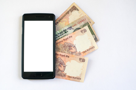 Currency notes held behind a mobile phone. Mobile phone with indian currency set on a white background. Denoting payment through mobile and mobile walletsの写真素材