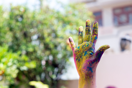 Colorful hand shot against a blurred background during the hindu festival of Holiの写真素材