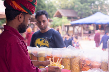 Traditionally dressed rajasthani vendor preparing bhel puri street food for foodのeditorial素材