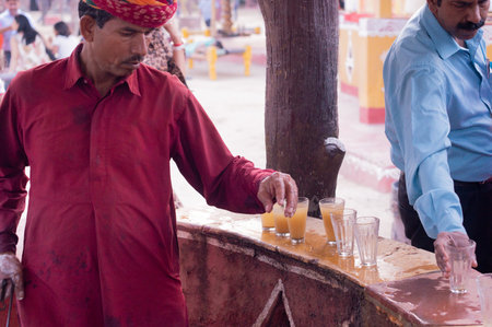 Traditionally dressed rajasthani vendor preparing bhel puri street food for foodのeditorial素材