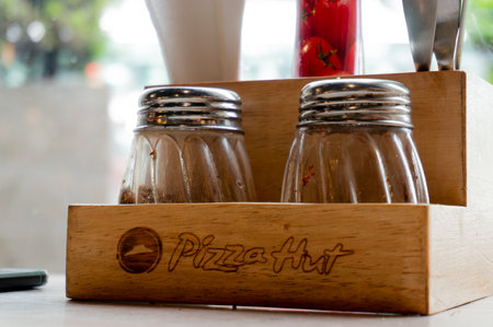 Wooden salt pepper oregano and chili flakes shaker and tissue holder at Pizza hut in indiaのeditorial素材
