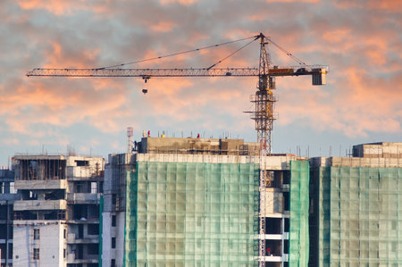 Under construction building with a crane on top and safety netsのeditorial素材