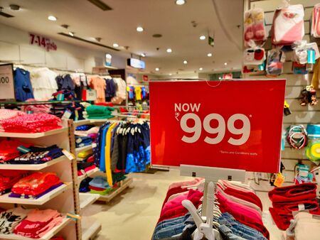 Sale price of Rs 999 for specific clothes on the top of hangers in a clothing store. the multiple...