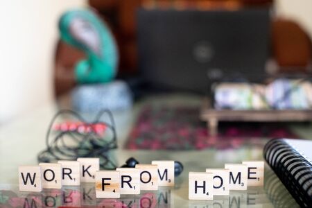 Wooden blocks with work from home set on a marble table with sprial binding notebook and penの写真素材