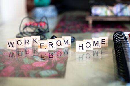 Wooden blocks with work from home set on a marble table with sprial binding notebook and penの写真素材