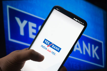 A mobile logged into the yes bank mobile application infront of the yes bank boardのeditorial素材