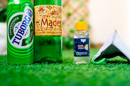 Gurgaon, Haryana, India - circa 2020 : Alcohol liquor wine beer placed on grass at the entrance of house with mask and sanitizer showing home delivery of alcohol during coronavirus pandemic. Shows the opening up of alcohol selling guidelines in Gurgaon, Bのeditorial素材