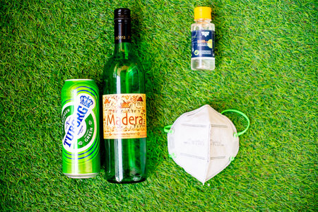 Gurgaon, Haryana, India - circa 2020 : Flatlay of alcohol liquor bottles on grass with a mask and sanitizer showing the home delivery and purchase of alcohol and liquor during coronavius lockdown. Shows the rewriting of alcohol selling guidelines in the cのeditorial素材