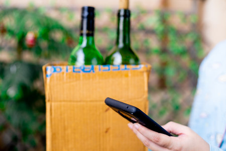 Gurgaon, Haryana, India - circa 2020 : Young indian girl carrying a cardboard box of alcohol liquor that has been home delivered through an online app. Shows concept of government guidelines to allow home delivery of alcohol liquor through online startupsのeditorial素材