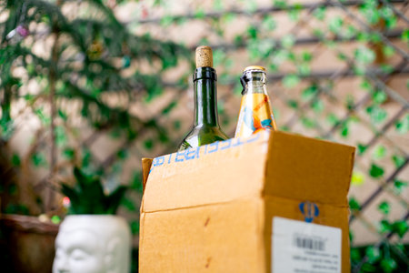 Gurgaon, Delhi, India - circa 2020 : Alcohol in a cardboard box with beer and wine home delivered through online app shot in a garden at home. Concept on government guideline on home delivery of alcohol liquor amidst the coronavirus pandemic lockdownのeditorial素材